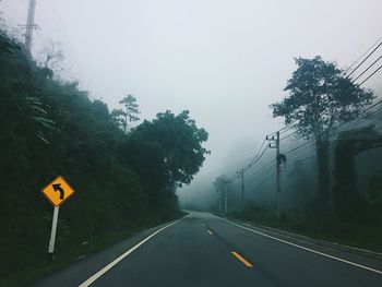 Road amidst trees against sky during rainy season