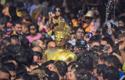 Buddha statue amidst people during traditional festival