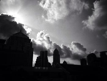 Buildings in city against cloudy sky