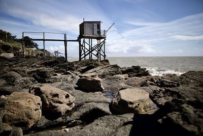 View of rocks on beach against sky