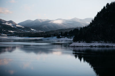 Scenic view of lake and snowcapped mountains against sky