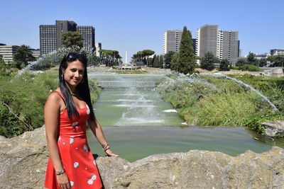 Portrait of woman standing against water