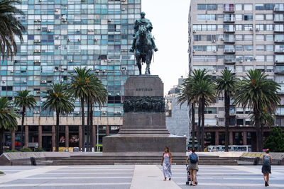 Statue of people in front of office building