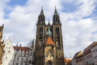 Low angle view of bell tower against cloudy sky