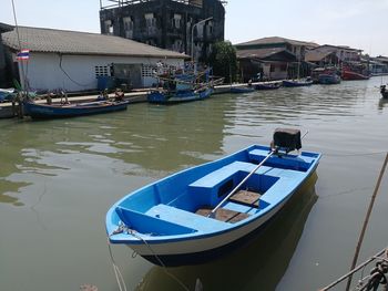 Boats moored at harbor by buildings in city