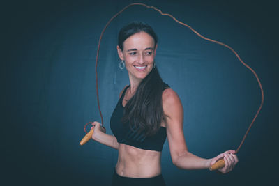 Portrait of a smiling young woman against black background