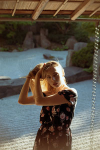 Portrait of young woman while standing outdoors