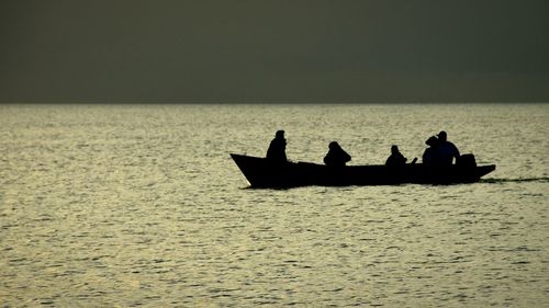 Silhouette of boat in sea at sunset