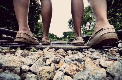 Low section of people walking amidst railroad tracks