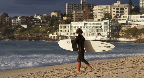 Man with surfboard walking at beach