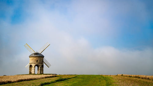 Traditional windmill on field against sky