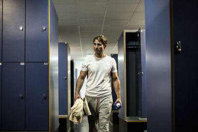 Man walking in locker room of health club