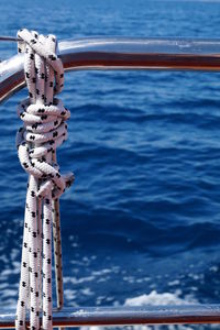 Close-up of rope tied to boat sailing in sea