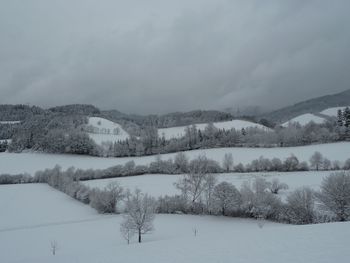 Snow covered landscape against sky