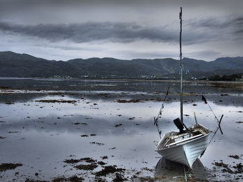 Scenic view of lake and mountains against cloudy sky