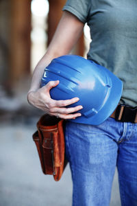 Close up of a female construction worker holding a hard hat