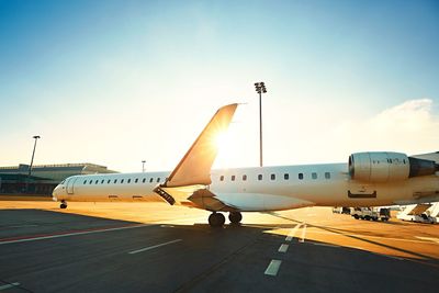 Airplane on airport runway against sky