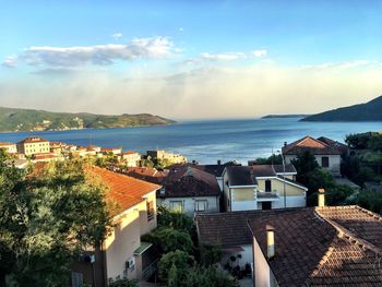 High angle view of townscape by sea against sky