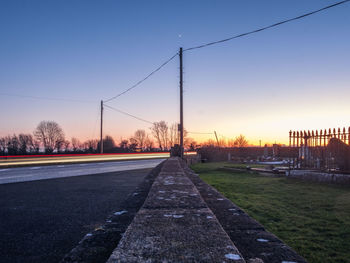 Road against clear sky during sunset