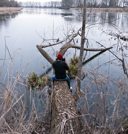 Rear view of man working in lake