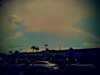 Rainbow over residential district against sky