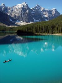 Lake and trees with mountain against sky