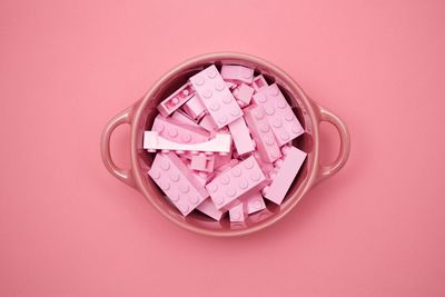 Close-up of pink flower on table against white background