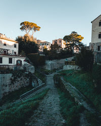 Footpath amidst old buildings against sky