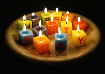 High angle view of lit birthday candles in plate at darkroom