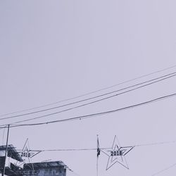 Low angle view of power lines against clear sky