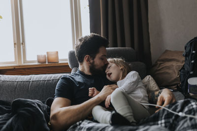 Father hugging disabled child on sofa