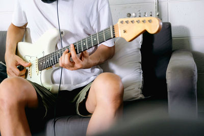 Midsection of woman playing guitar