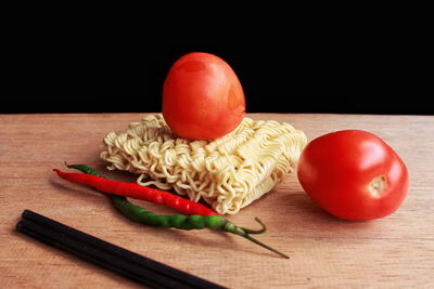 Close-up of tomatoes on table against black background