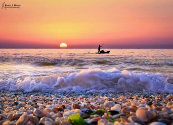 Silhouette man on beach against sky during sunset