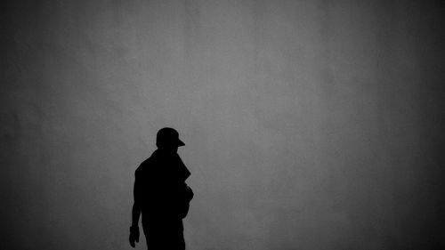 Silhouette man standing against wall