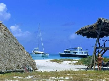 Ship moored on beach against clear blue sky