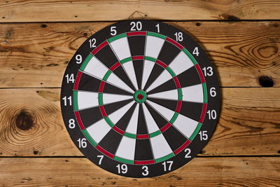 Dartboard hangs on the center of a wooden wall