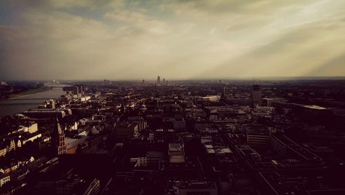 Aerial view of cityscape against cloudy sky