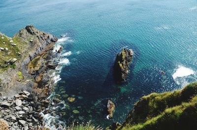 High angle view of rock by sea against sky