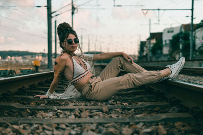 Portrait of young woman sitting in city