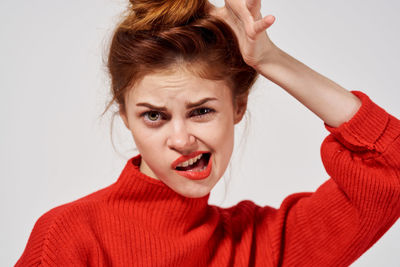 Portrait of beautiful young woman against white background