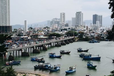 High angle view of boats moored on river amidst buildings in city