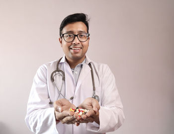 Portrait of smiling young man holding eyeglasses