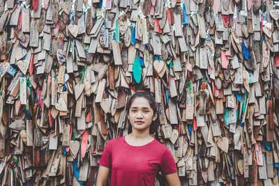 Portrait of young woman standing against prayer blocks