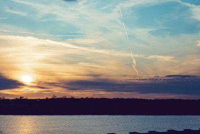 Scenic view of sea against dramatic sky during sunset