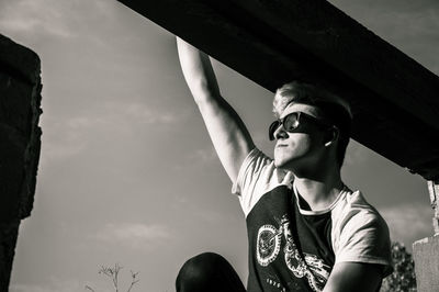 Low angle view of man wearing sunglasses against sky