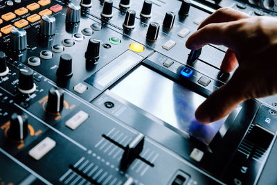 Close-up of cropped hand on control panel of turntable