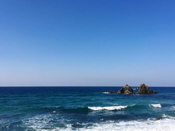 Scenic view of sea against clear blue sky