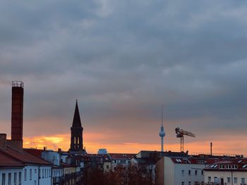 Buildings in city against sky during sunset