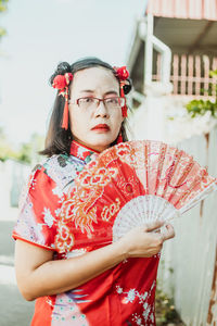 Young woman with umbrella standing outdoors